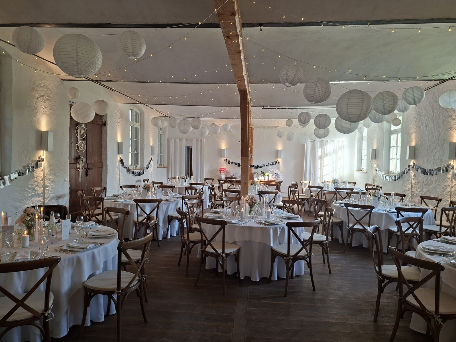 Remise des Schloss Dürrenmungenaus Dekorierter Saal mit weißen Lampions und Holzstühlen