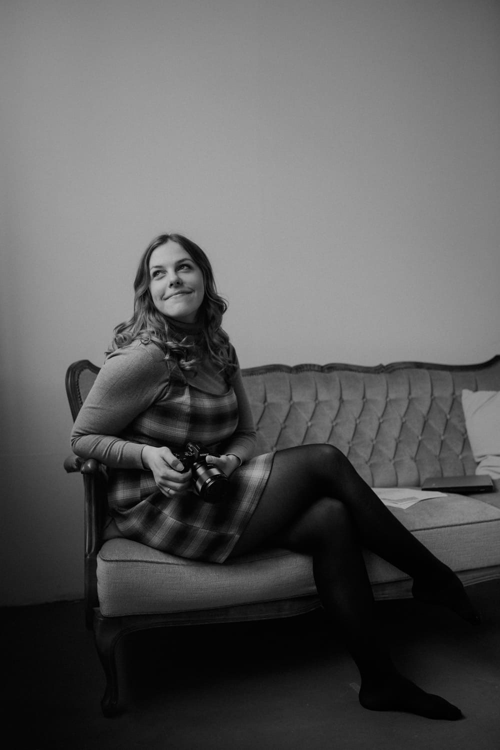 IsabelMichos margitandsera sitzt auf einem Sofa und lächelt 