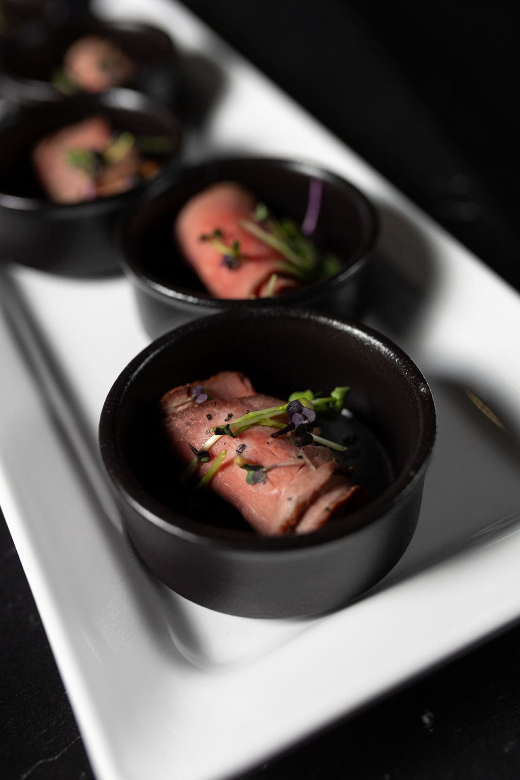 Nahaufnahme von Fleischhäppchen in schwarzer kleiner Schüssel 