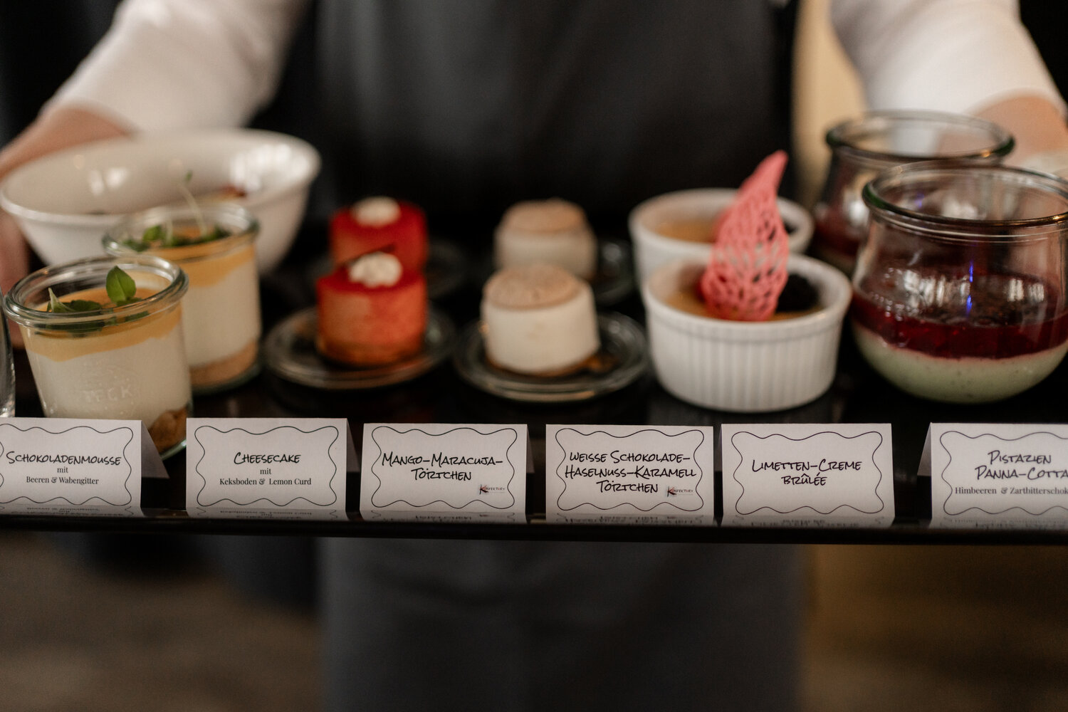 sechs verschiedene Dessertschälchen auf einem Tablett