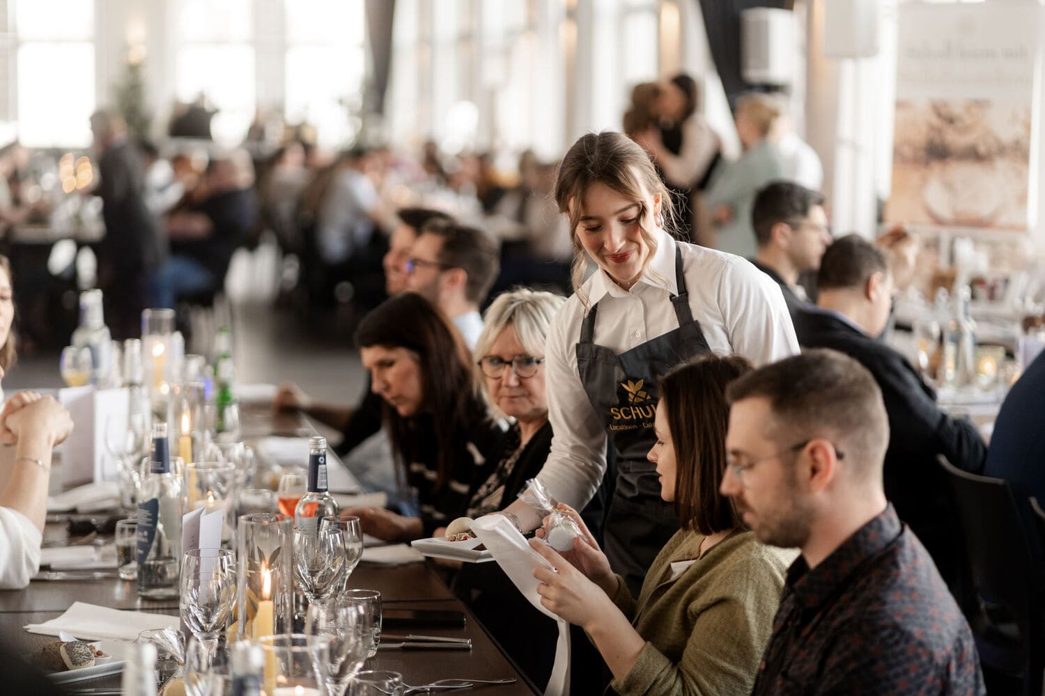 Eine Mitarbeiterin von Schuler Events serviert einen kleinen Teller einem Gast