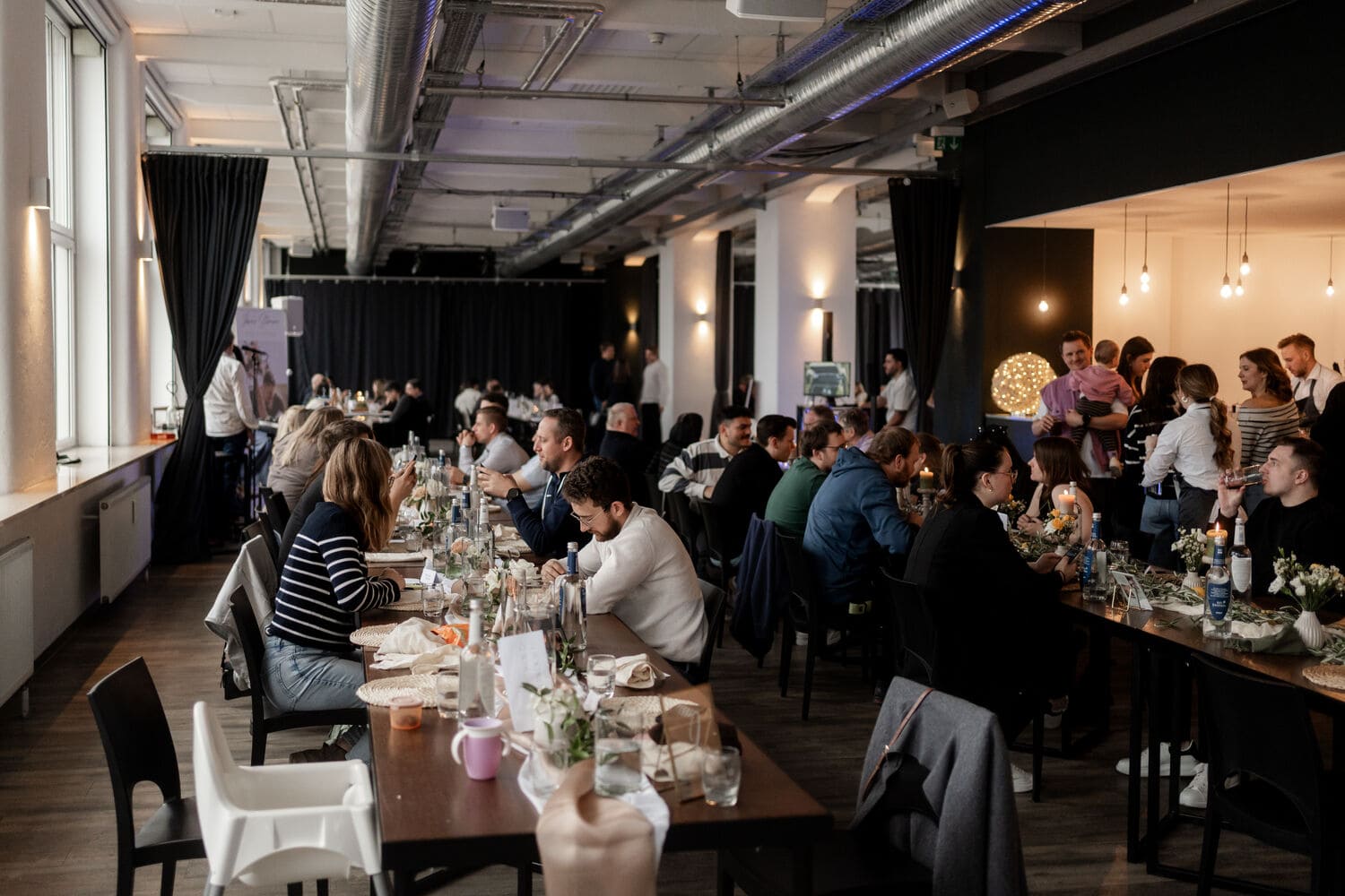 Viele Gäste sitzen an den dekorierten Tischen im Loftwerk Nürnberg