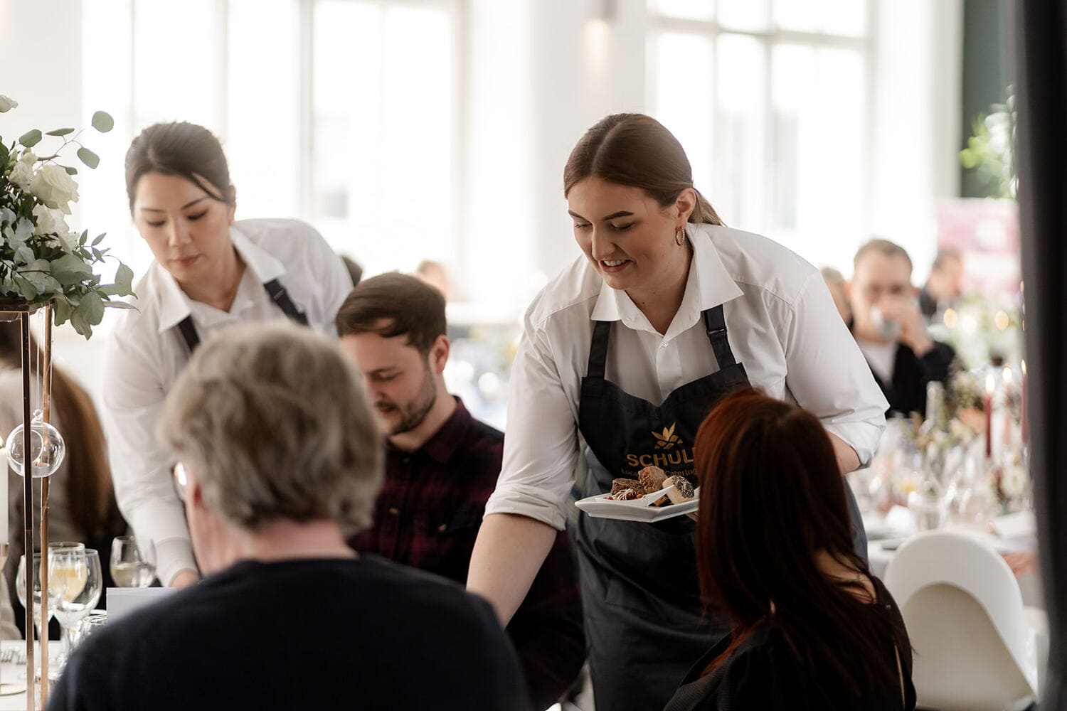Servicekraft serviert Essen zum Gast